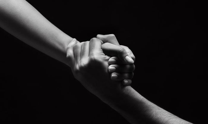 Two hands clasped together, one steadying the other.